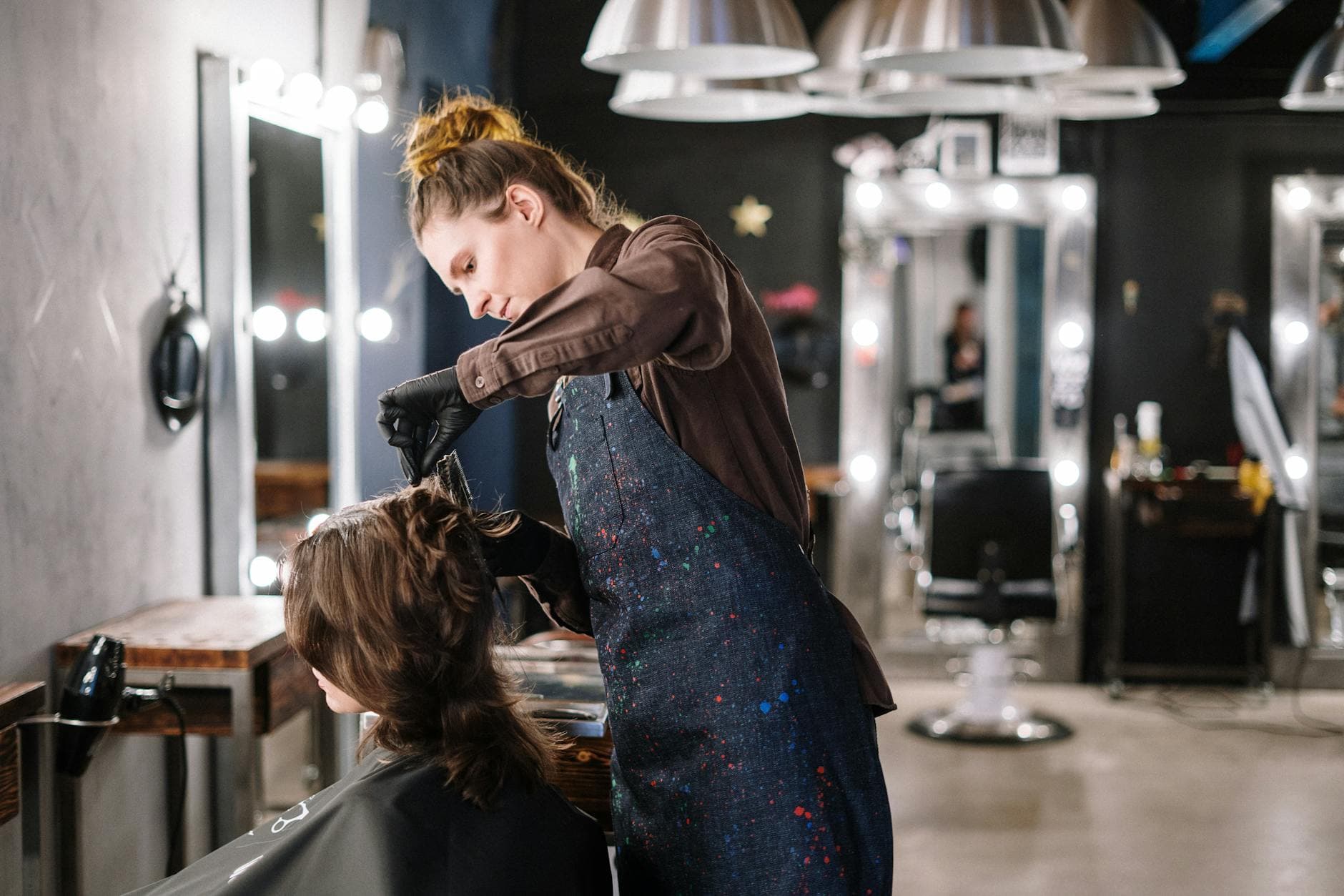 Hair stylist applying colour to a client in a modern salon